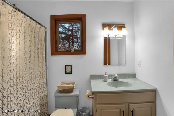a bathroom with a sink mirror and toilet