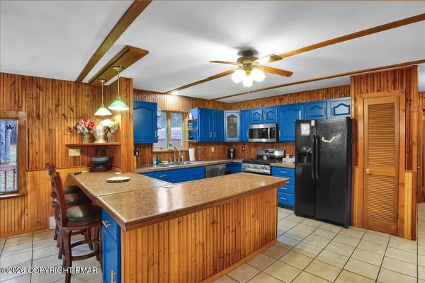 a kitchen with stainless steel appliances granite countertop a refrigerator a sink dishwasher and a stove with wooden cabinets