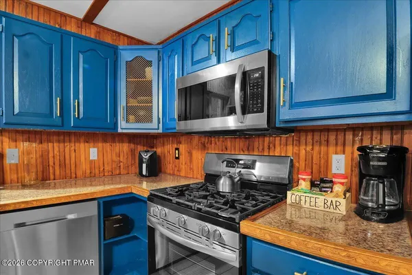 a kitchen with stainless steel appliances granite countertop a stove and a microwave