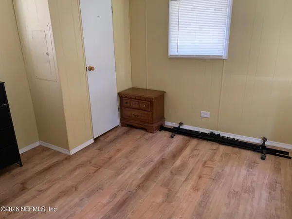 a view of a room with wooden floor and a chair