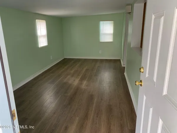 a view of a hallway with wooden floor and stairs