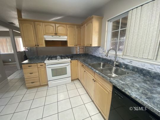 519 South Fairview Street Ridgecrest, CA 93555 - Photo 7 of 20 a kitchen with a sink stove and cabinets