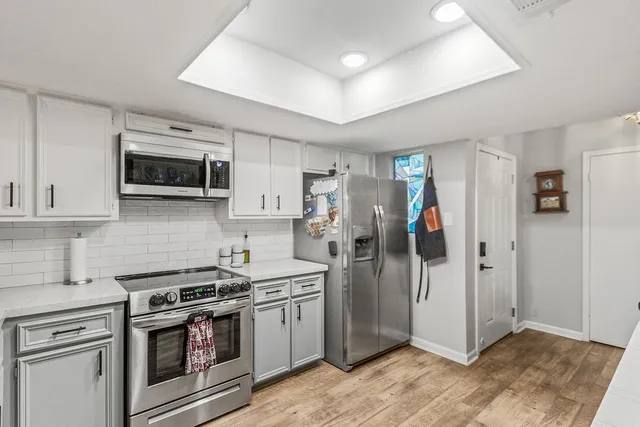 a room with stainless steel appliances kitchen island a refrigerator and cabinets