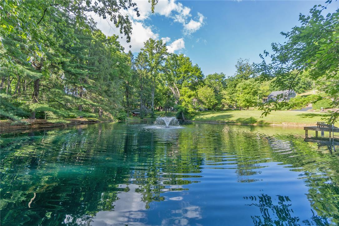 1325 Granger Road Northampton, PA 18067 - Photo 8 of 61 A tranquil pond with a decorative fountain offers a serene waterside experience, perfect for quiet reflection.
