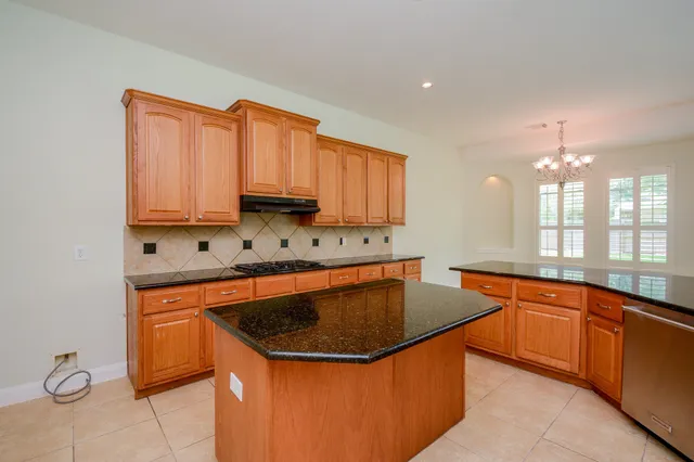 a kitchen with stainless steel appliances granite countertop a sink a stove a microwave and island