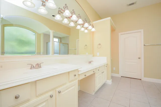 a bathroom with a granite countertop sink a large mirror and a shower