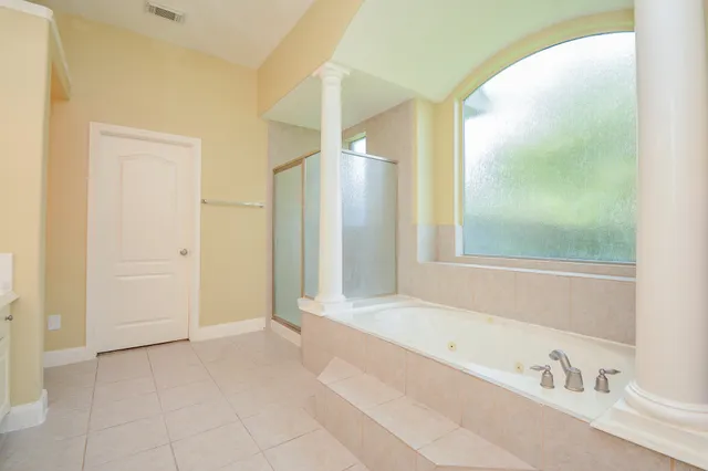 a bathroom with a tub sink and mirror