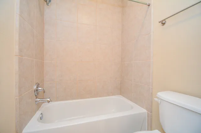 a white bath tub sitting next to a white toilet and sink