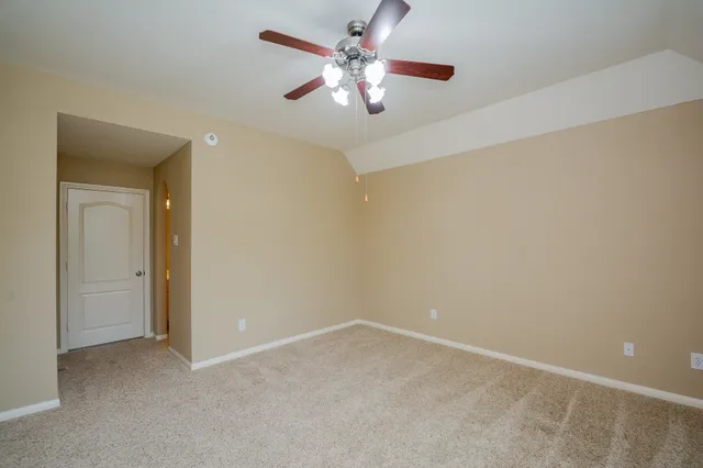 a view of a room with a ceiling fan and a window