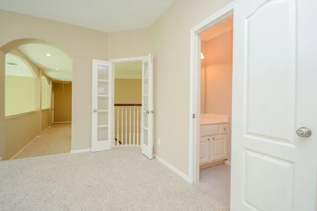a view of a livingroom with wooden floor and a bathroom