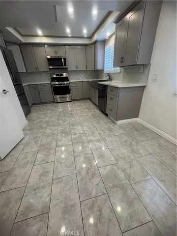 a large kitchen with stainless steel appliances a large counter top