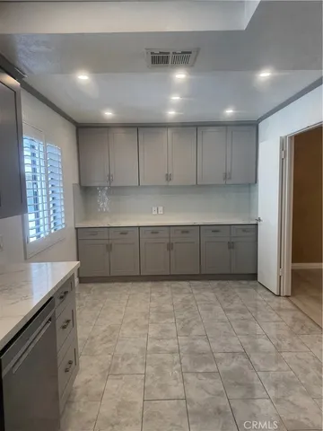 a view of kitchen with granite countertop cabinets and entryway