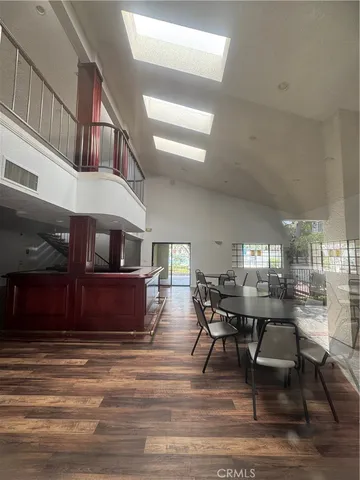 a living room with couches and kitchen view with wooden floor