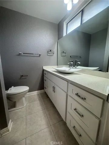 a spacious bathroom with a granite countertop sink a toilet and a mirror