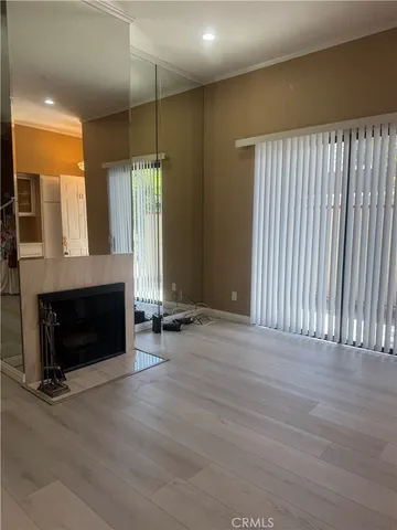 an empty room with wooden floor and fireplace