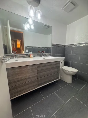 a bathroom with a double vanity sink mirror and toilet