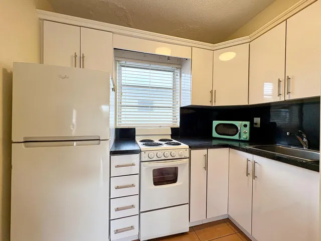 a kitchen with a refrigerator sink stove and cabinets