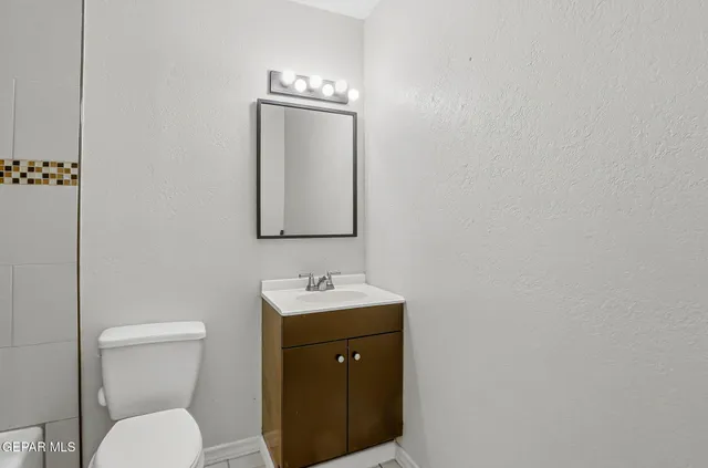 a bathroom with a toilet a sink and mirror
