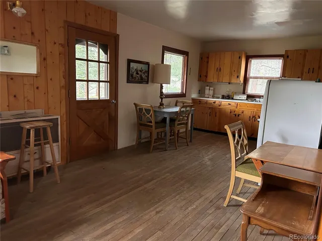 a living room with furniture a dining table and wooden floor