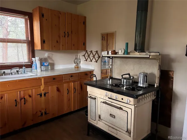 a kitchen with granite countertop a sink stove and cabinets