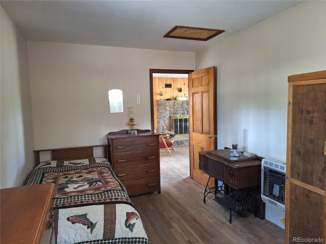 a bedroom with a bed and a dresser next to a window