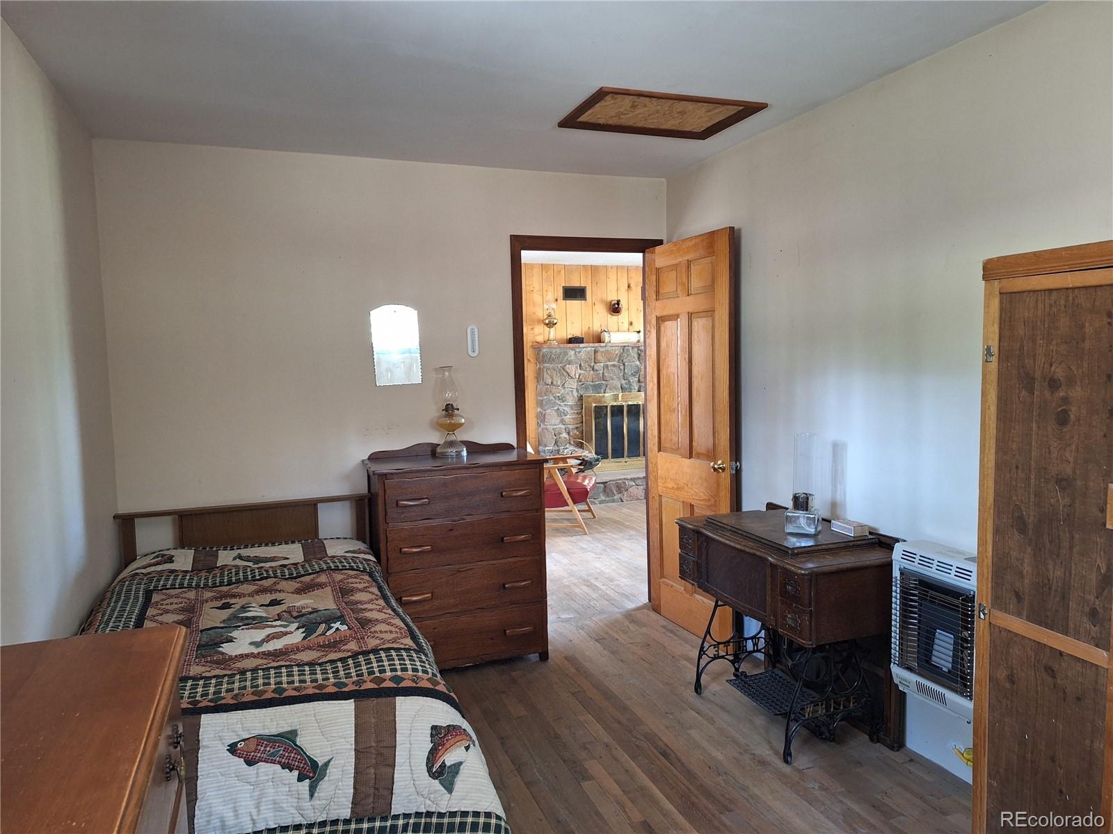 861 Happy Top Road Bailey, CO 80421 - Photo 20 of 29 a bedroom with a bed and a dresser next to a window