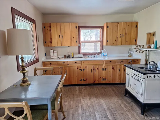 a kitchen with a stove a sink a counter space and a refrigerator