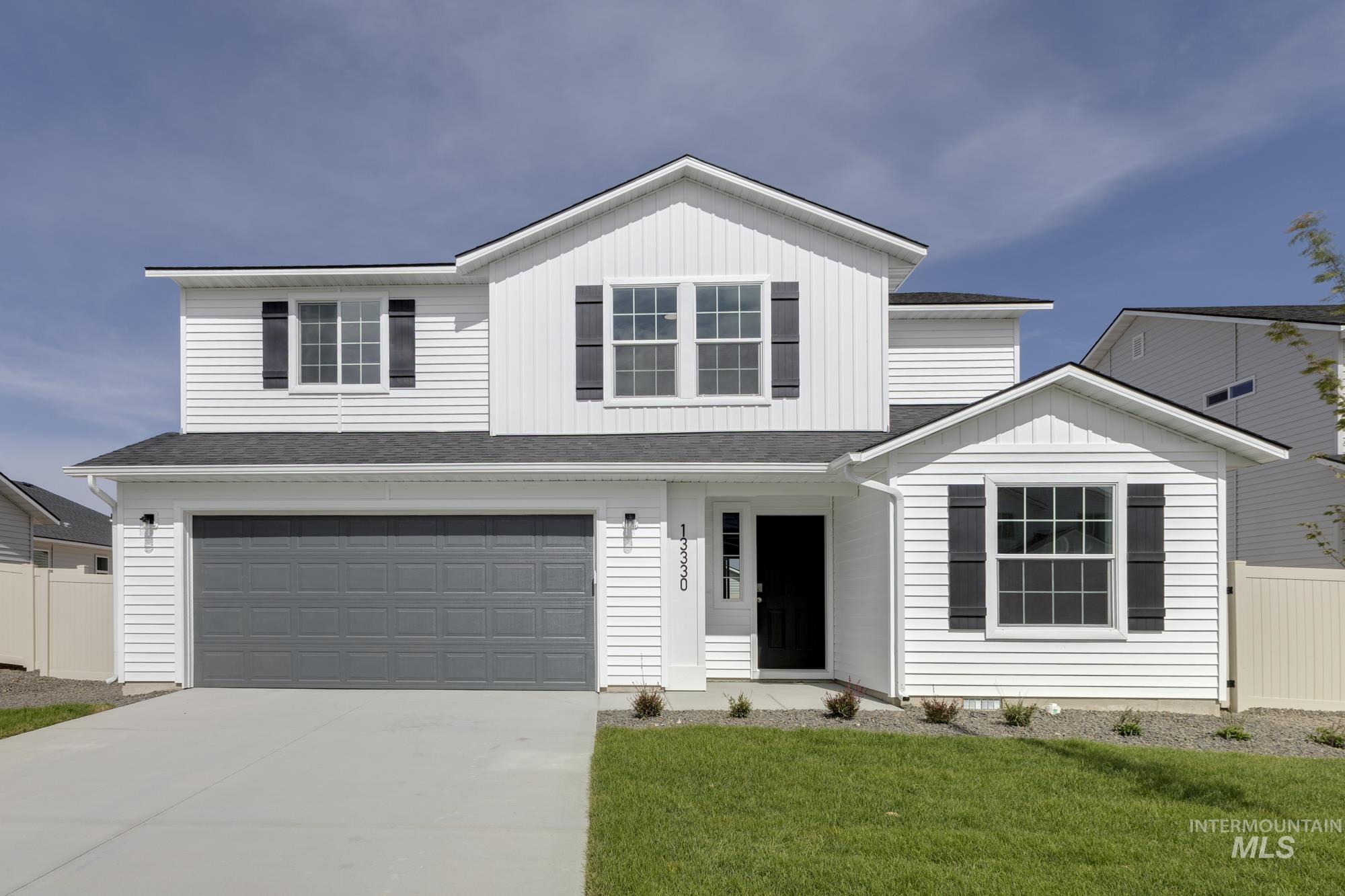 13330 Cut Street Caldwell, ID 83607 - Photo 1 of 1 Traditional-style home with roof with shingles, concrete driveway, an attached garage, board and batten siding, and a porch