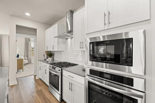 a kitchen with stainless steel appliances a stove microwave and cabinets