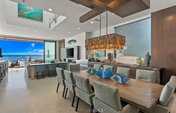 a dining room with stainless steel appliances kitchen island granite countertop a table chairs and a stove