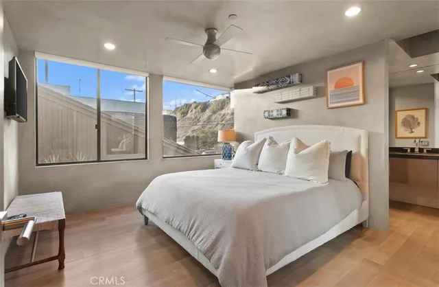 a bedroom with a bed and a flat tv screen on wall