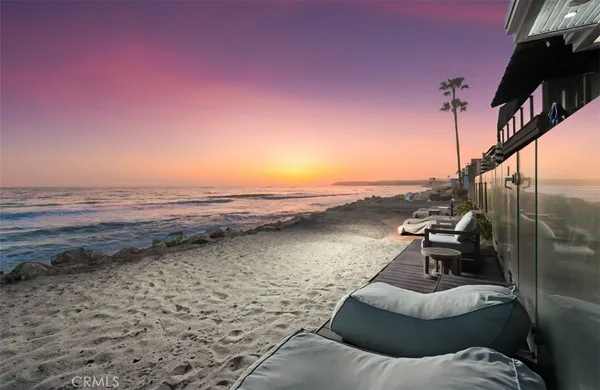 a view of a lake with lawn chairs and wooden fence