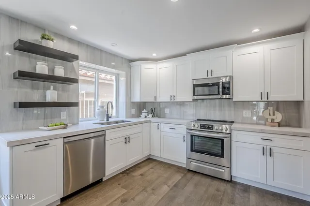 a kitchen with white cabinets and stainless steel appliances