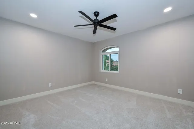 a view of an empty room with a ceiling fan