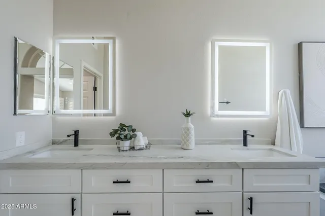 a large white kitchen with a sink and dishwasher with wooden floor