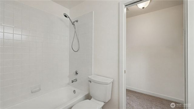 a bathroom with a granite countertop toilet and a shower