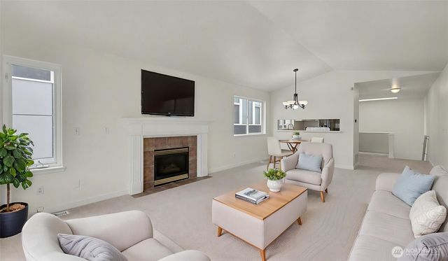 a living room with furniture a fireplace and a flat screen tv