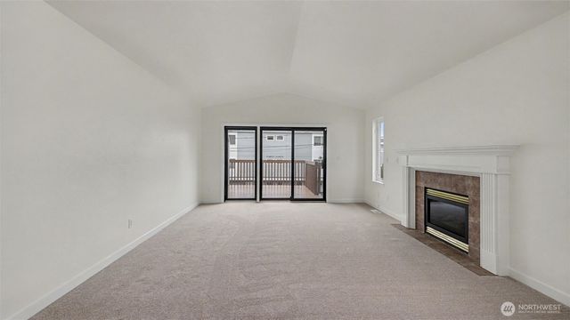 an empty room with windows and fireplace