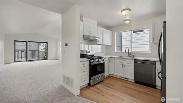 a kitchen with stainless steel appliances granite countertop a stove and a refrigerator