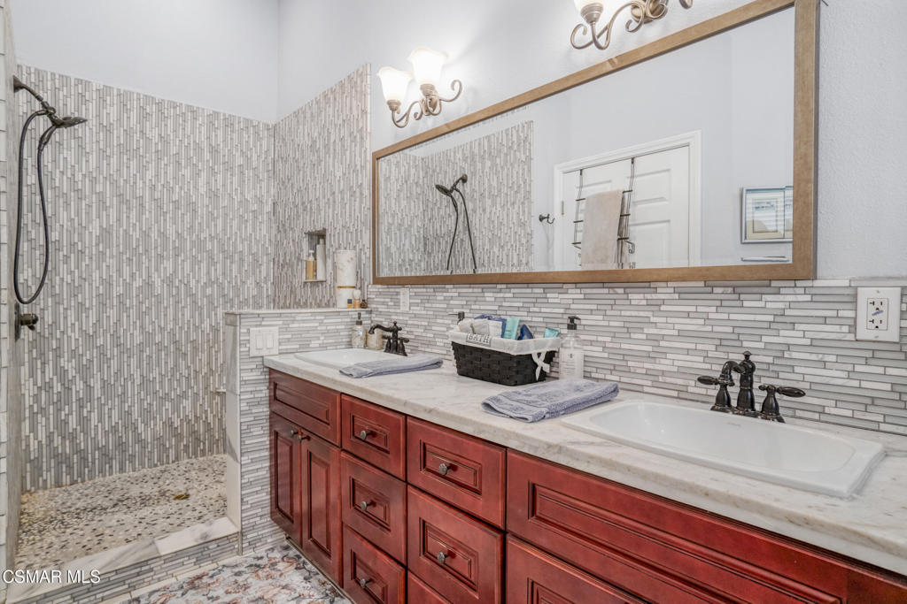 7368 Santa Susana Pass Road Simi Valley, CA 93063 - Photo 21 of 48 a bathroom with double vanity sink a mirror and shower