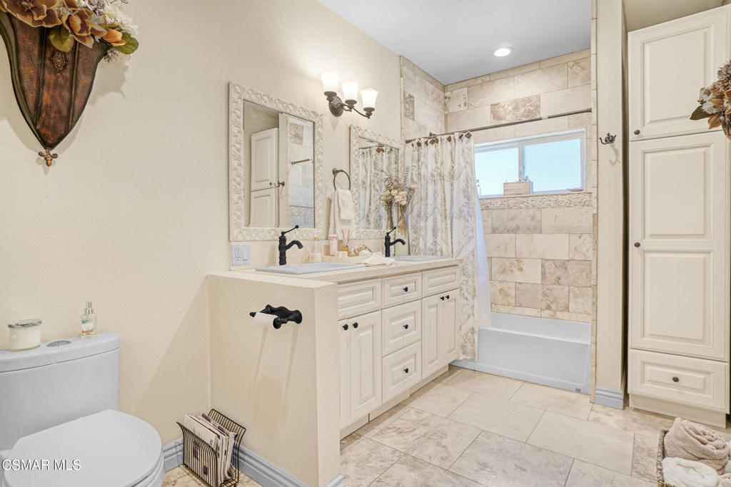 7368 Santa Susana Pass Road Simi Valley, CA 93063 - Photo 28 of 48 a bathroom with a granite countertop sink a mirror a toilet and shower