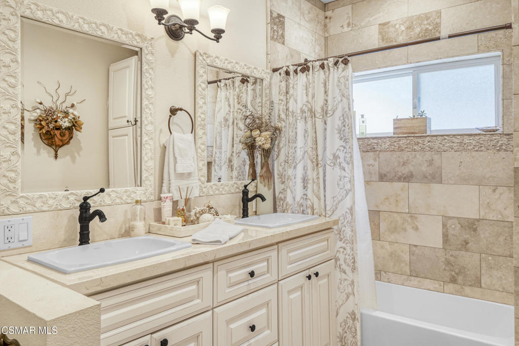 7368 Santa Susana Pass Road Simi Valley, CA 93063 - Photo 29 of 48 a bathroom with a granite countertop sink a mirror a vanity and a shower