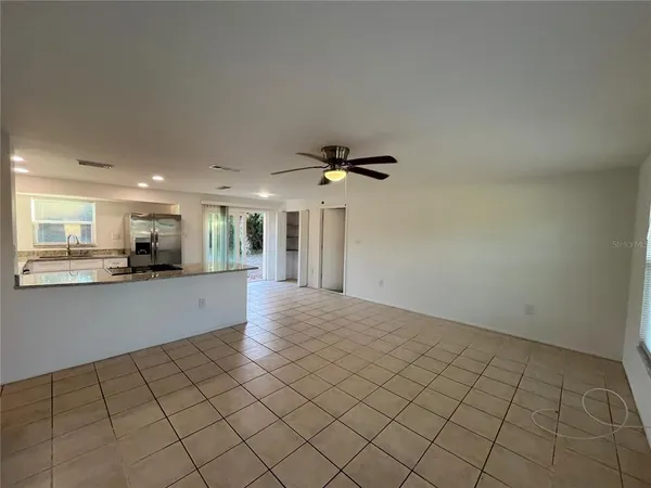 a view of an empty room and kitchen view