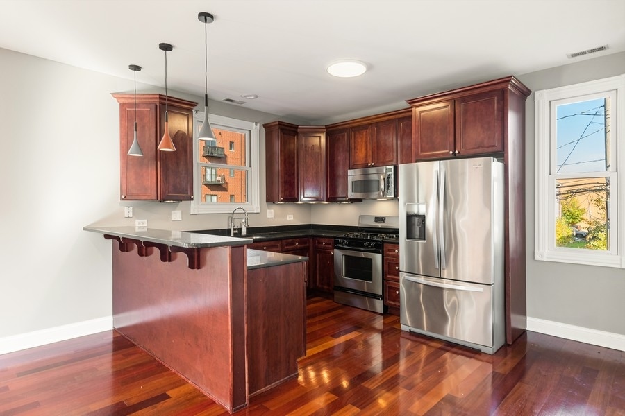 2340 West Adams Street, Unit 33 Chicago, IL 60612 - Photo 5 of 17 a kitchen with stainless steel appliances granite countertop a refrigerator a sink and a stove