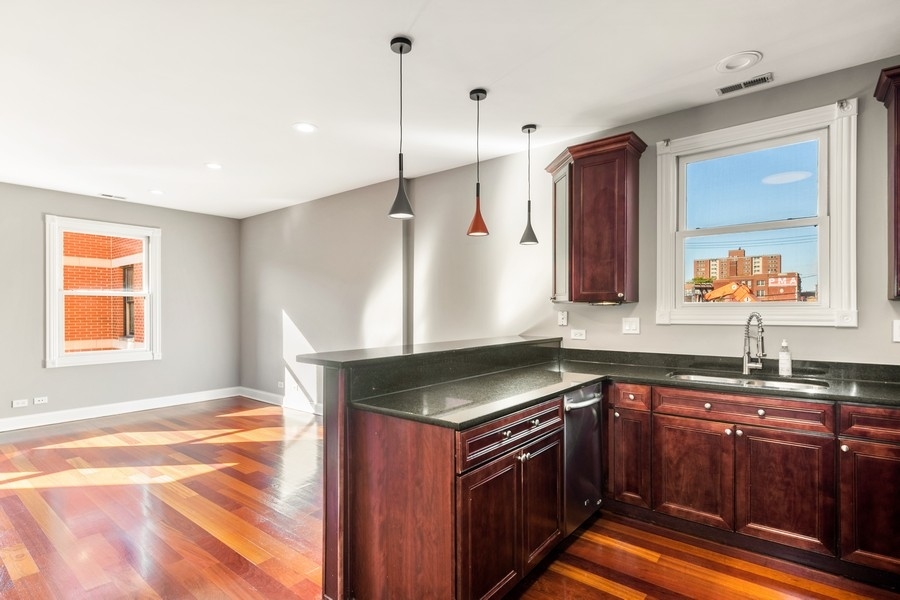2340 West Adams Street, Unit 33 Chicago, IL 60612 - Photo 6 of 17 a kitchen with granite countertop a sink and a stove