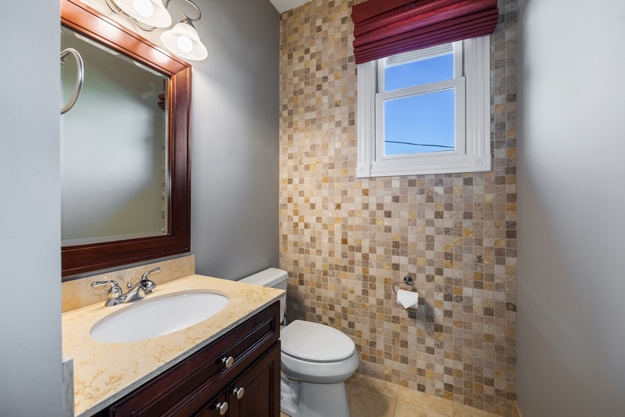 2340 West Adams Street, Unit 33 Chicago, IL 60612 - Photo 9 of 17 a bathroom with a granite countertop toilet a sink and a mirror