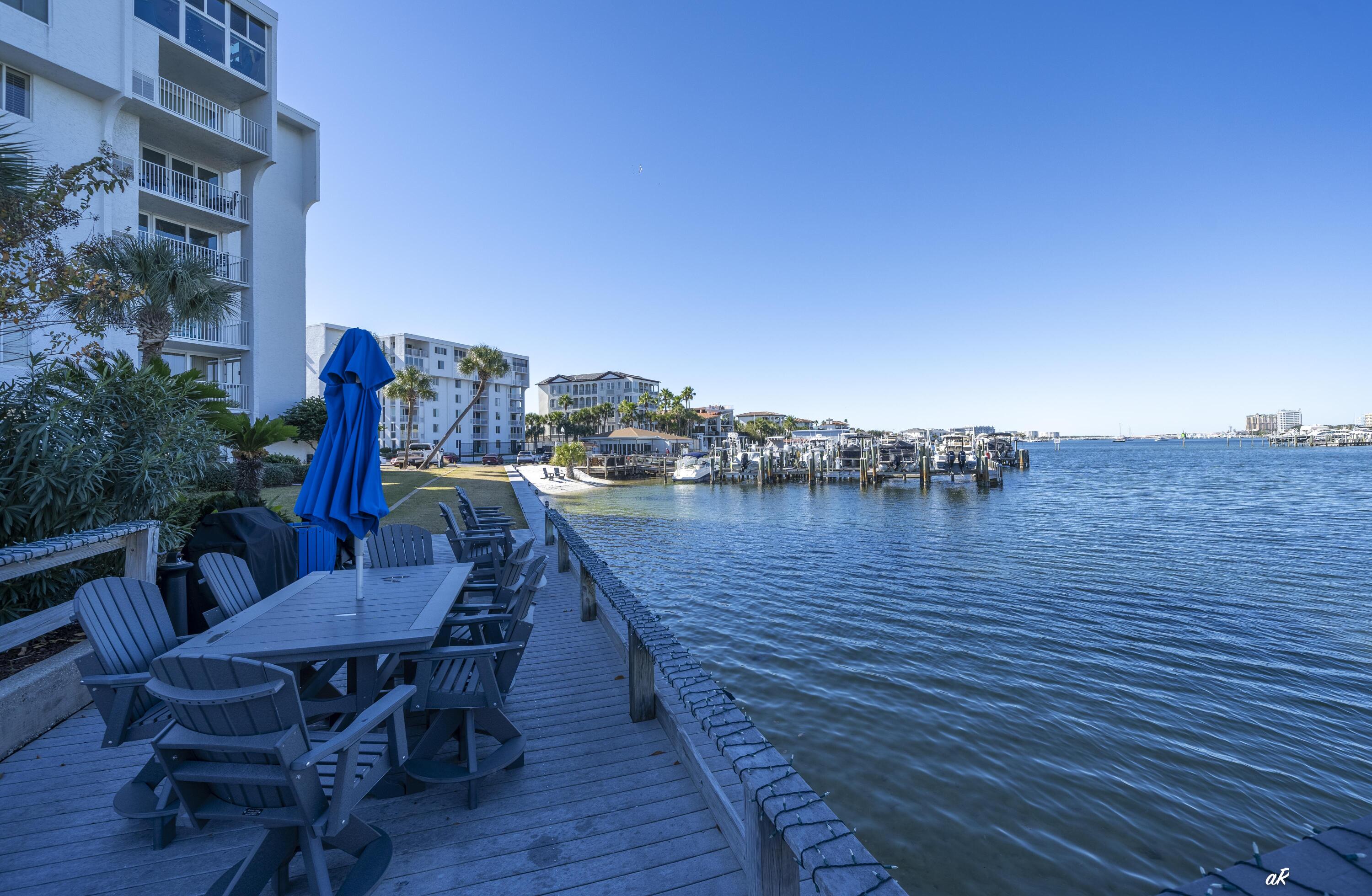 30 Moreno Point Road, Unit 404A Destin, FL 32541 - Photo 40 of 52 a view of a chairs and table on wooden deck