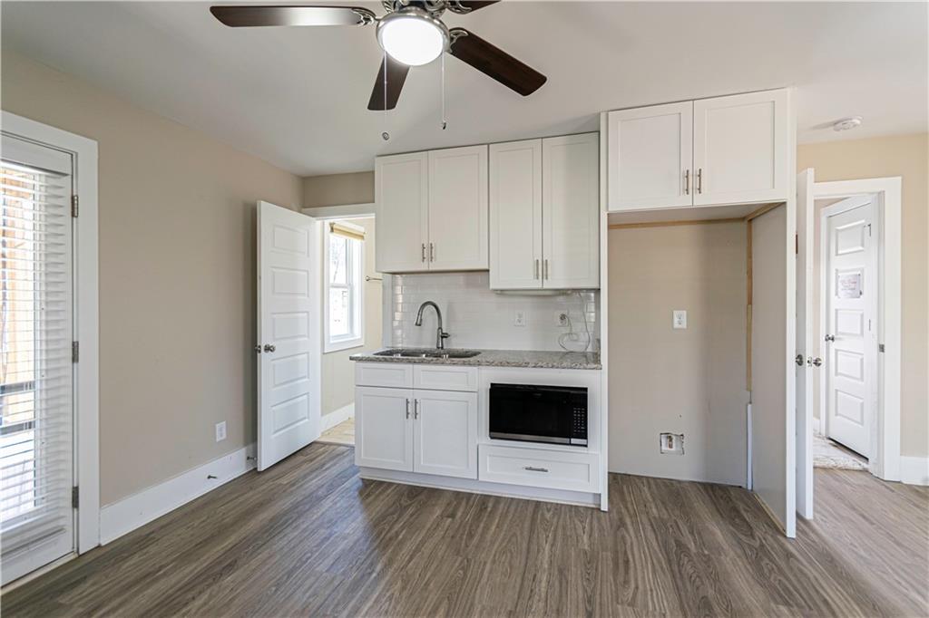3336 Donna Way Gainesville, GA 30504 - Photo 22 of 30 a kitchen with stainless steel appliances a white cabinets and wooden floor