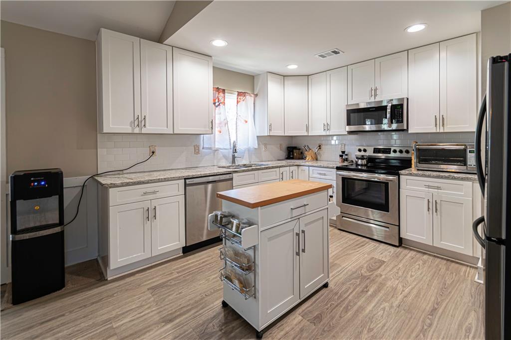 3336 Donna Way Gainesville, GA 30504 - Photo 9 of 30 a kitchen with white cabinets stainless steel appliances and sink