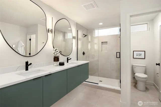 a bathroom with a double vanity sink mirror and toilet